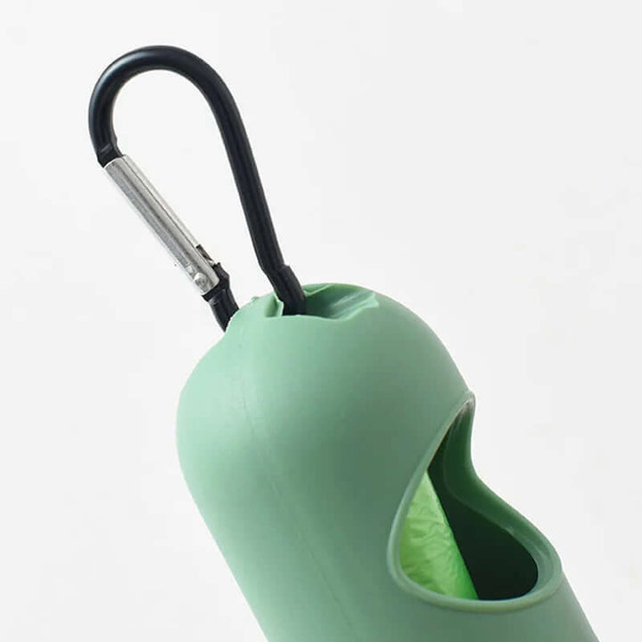 Close-up of a green LED light pet waste bag dispenser with a secure carabiner for easy attachment to leashes.