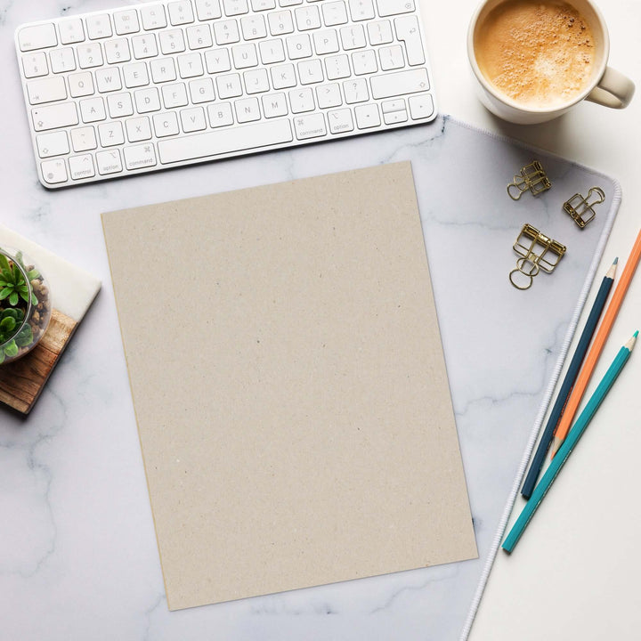 Blank notepad on a workspace with a keyboard, coffee, and stationery, perfect for jotting down ideas.