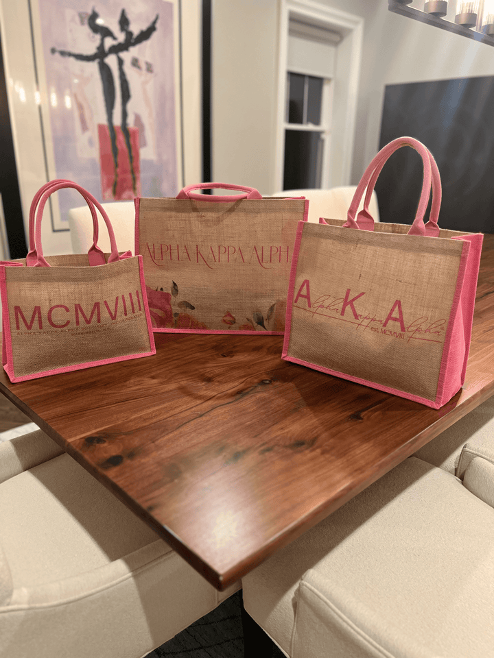 Stylish Alpha Kappa Alpha tote bags featuring vibrant pink accents, perfect Greek gear for sorority paraphernalia.