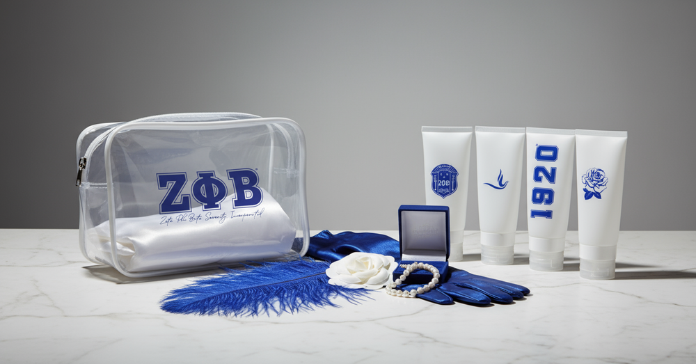 Zeta Phi Beta clear cosmetic travel set styled with pearls, gloves, feather, and sorority accessories by A&W Greek Shop.